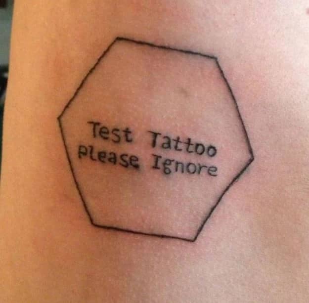 Simple hexagon line art enclosing the text test tattoo please ignore representing funny tattoos.