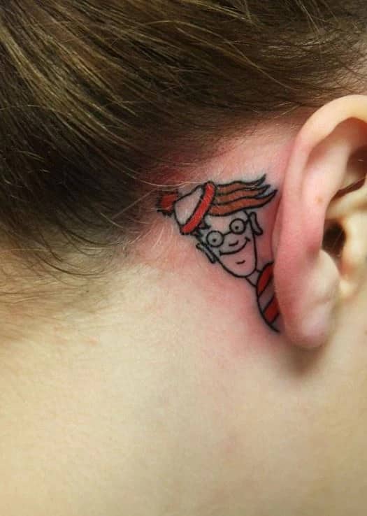 Where's Waldo character tattooed hiding cleverly behind an ear highlighting interactive funny tattoos.