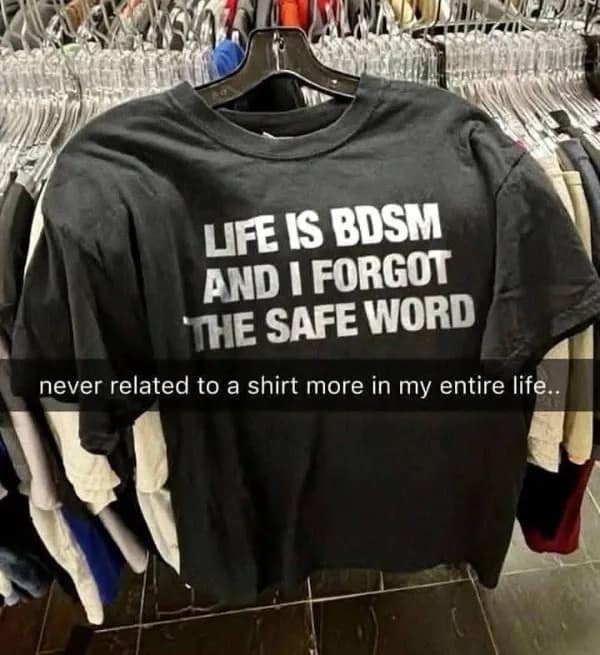 A thrift store graphic tee featured in a meme dump reading "LIFE IS BDSM AND I FORGOT THE SAFE WORD" hanging on a rack.