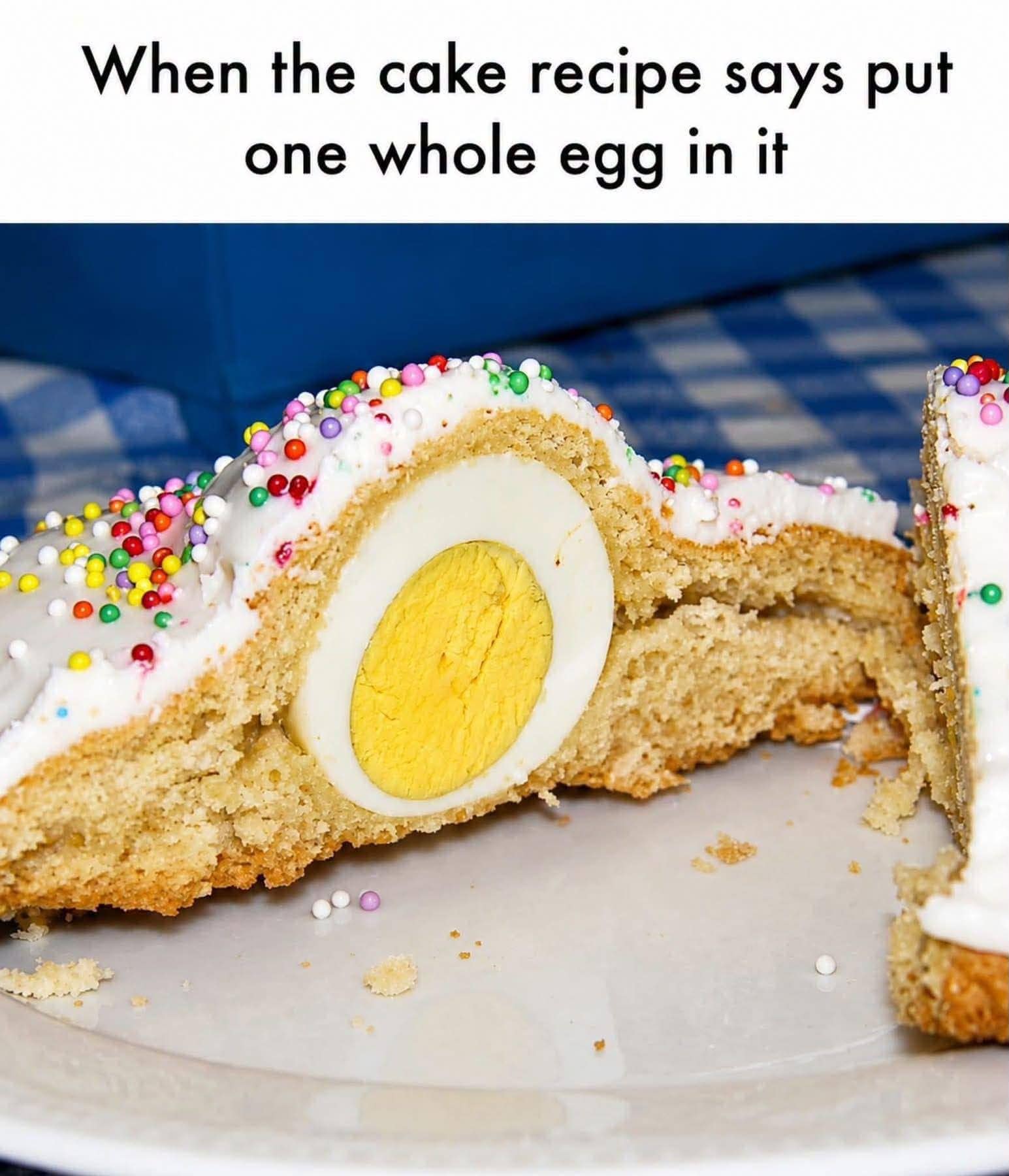 A literal cooking fail meme dump photo showing a slice of frosted sprinkle cake with an entire hard-boiled egg baked whole inside, captioned "When the cake recipe says put one whole egg in it."