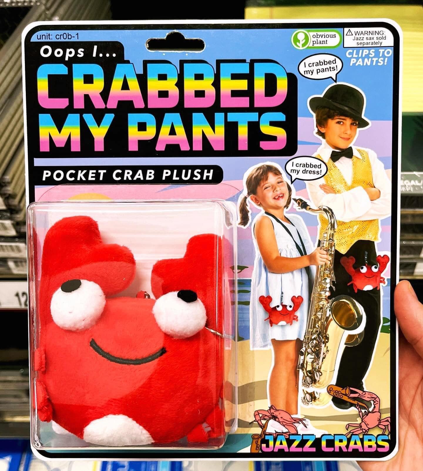 An Obvious Plant fake toy product in this funny meme set showcasing an "Oops I... CRABBED MY PANTS" pocket plush crab with children playing saxophone labeled "JAZZ CRABS."