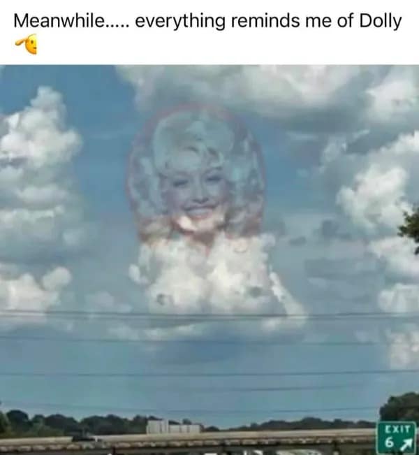 Cumulus cloud formation over a highway exit edited to look like Dolly Parton's iconic blonde hair and portrait, serving as a funny meme.