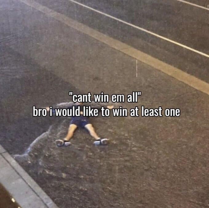 A defeatist exhaustion photo in this meme dump showing a person lying completely flat on their back on rain-slicked asphalt under text reading "'cant win em all' bro i would like to win at least one."