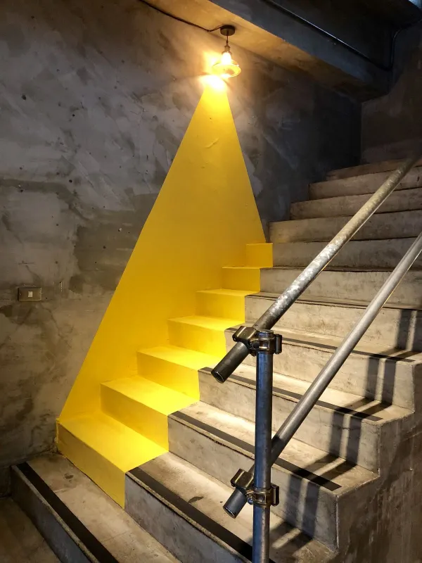 A clever optical illusion painting post in this meme dump showing concrete stairs painted with a bright yellow light beam extending directly from a hanging wall lamp.