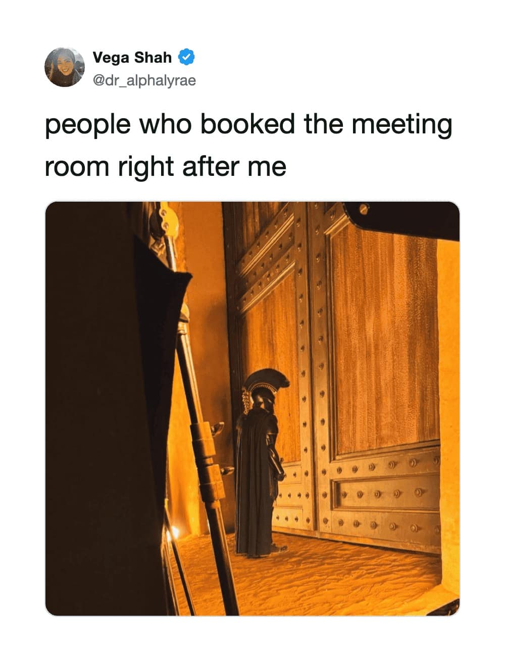 A corporate calendar tension post featured in a meme dump showing a Greek Spartan warrior waiting outside a massive wooden door for a meeting room to clear out.