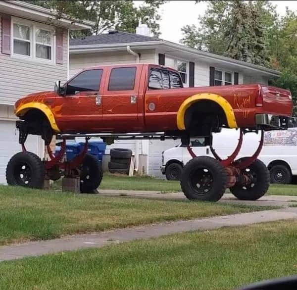 Unbelievably lifted red pickup truck meme showing ridiculously long suspension springs installed on wheels.