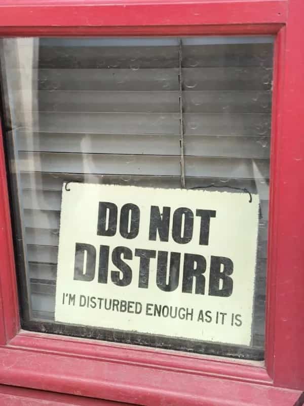 A humorous Do Not Disturb window sign stating I am disturbed enough as it is.