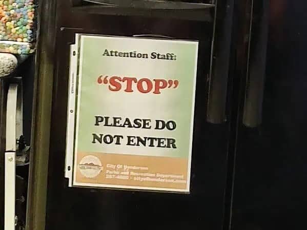 Sign on a door reading attention staff stop please do not enter with quotes around stop.