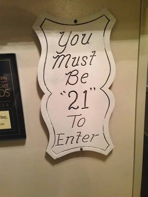 Handmade sign stating you must be twenty one to enter with unnecessary quotation marks.