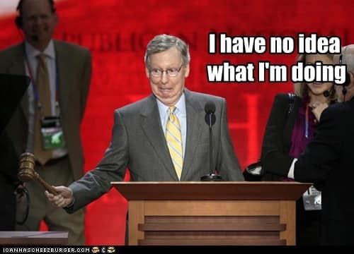 An old-school ICanHasCheezburger style Mitch McConnell meme, depicting McConnell at a podium awkwardly holding a wooden gavel, captioned "I have no idea what I'm doing."