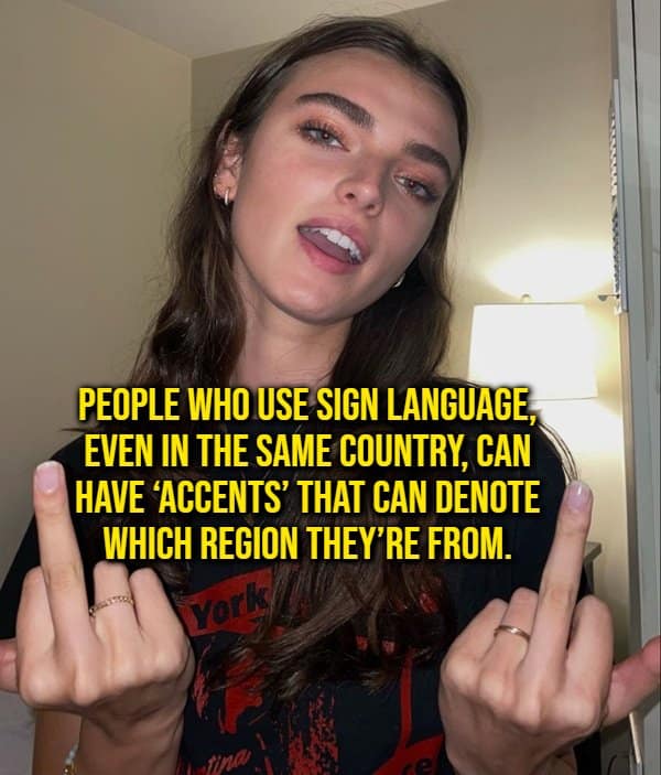 A hand-gesture linguistics random fact showing a woman holding up both middle fingers under text describing how sign language users can have regional accents.