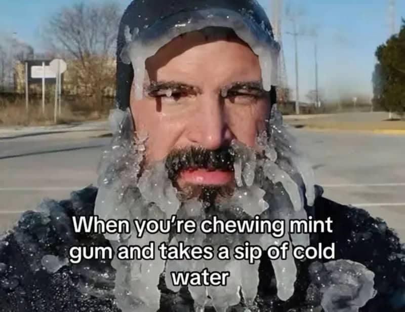 Close-up of a man's face and beard frozen solid with heavy icicles, illustrating the shock of drinking cold water right after chewing mint gum.