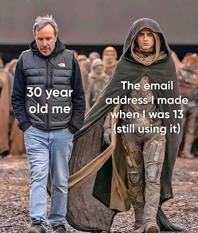 Movie set photo of director Denis Villeneuve walking alongside Timothée Chalamet in his Dune stillsuit and heavy cloak, illustrating a 30-year-old using a cringey childhood email address.