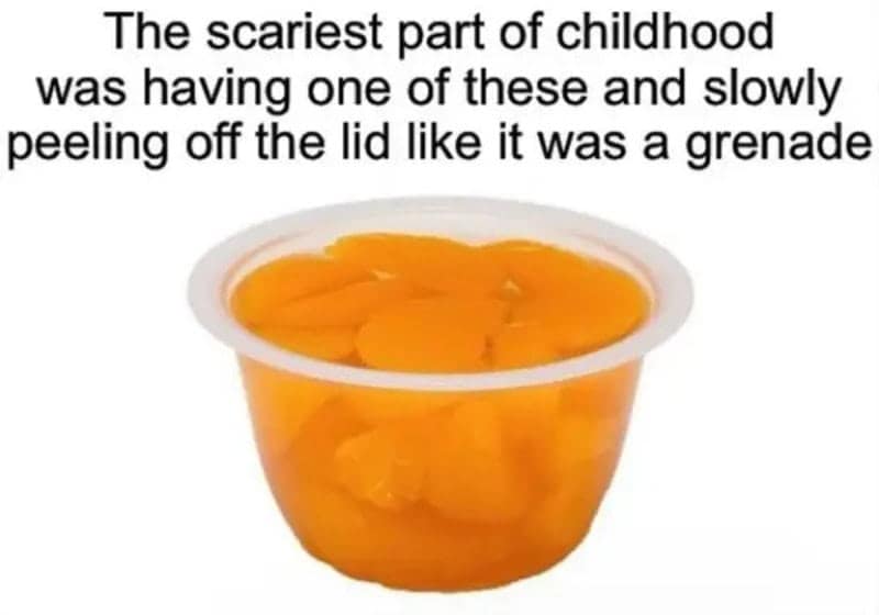 A plastic cup packed with mandarin orange slices in syrup, describing the intense childhood fear of peeling back the foil lid without splashing sticky juice everywhere.
