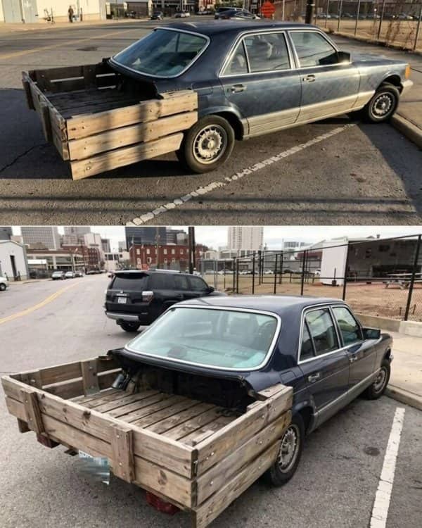 A vintage sedan converted into a custom pickup truck using an improvised wooden crate bed.