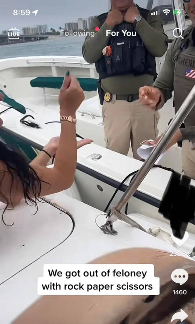 Woman on a boat playing rock paper scissors with police officers to escape felony charges.