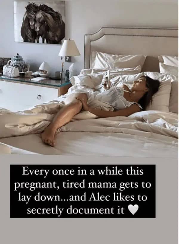 Woman posing in a bed while holding a phone claiming to be secretly photographed.