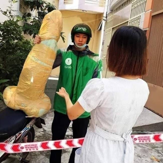 Delivery driver holding a giant phallic wrapped package for a confused woman customer.