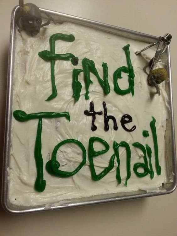 Disgusting party sheet cake frosted with the words Find the Toenail in green lettering.