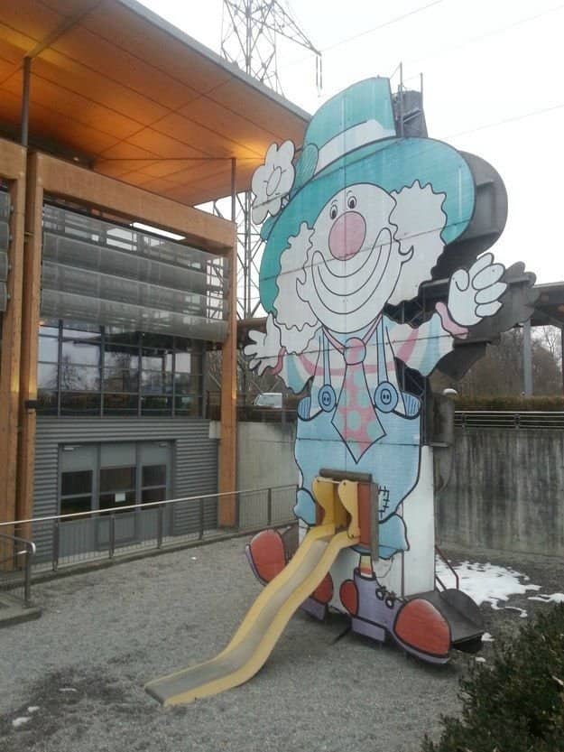 Giant creepy clown playground structure featuring a highly inappropriate crotch slide design at worst playgrounds.