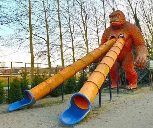 Giant gorilla playground statue featuring two long slides protruding from its chest among worst playgrounds.