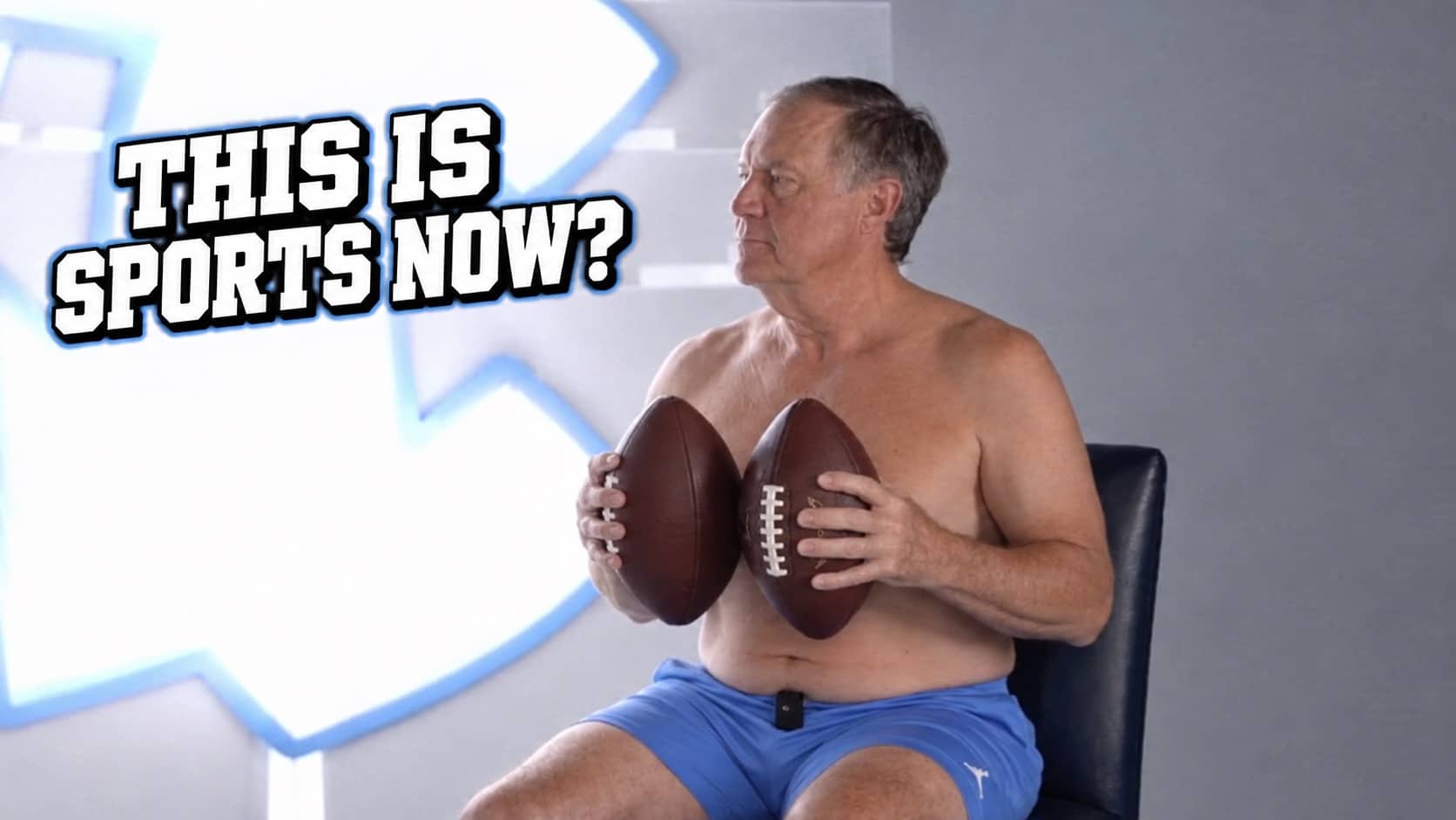 Shirtless Bill Belichick holding two footballs over his chest in a sports parody photo.
