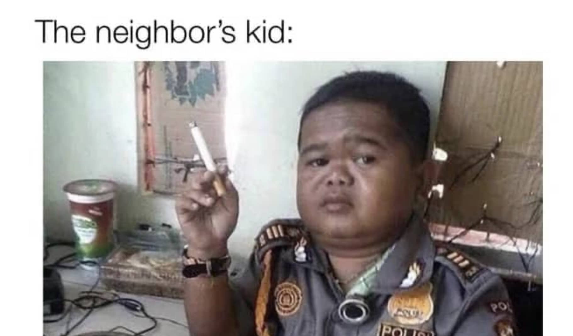 Meme of a young boy dressed in a police uniform holding a lit cigarette indoors.