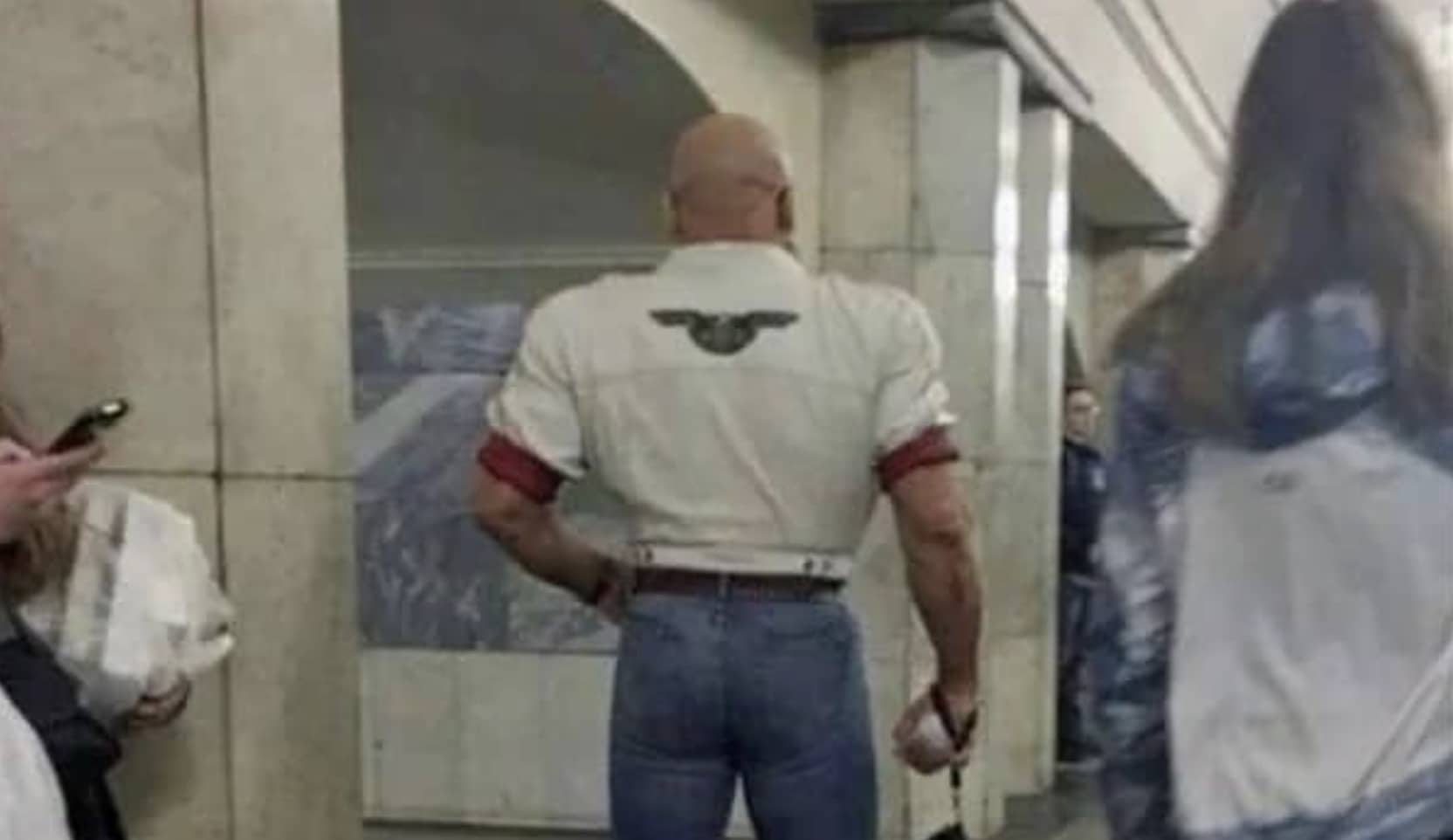 Muscular man wearing a tight cropped shirt and jeans indoors for funny memes gallery.