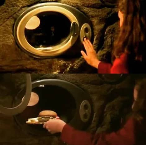 Spy Kids movie scene showing instant food machine dispensing burger meal onto wall shelf.