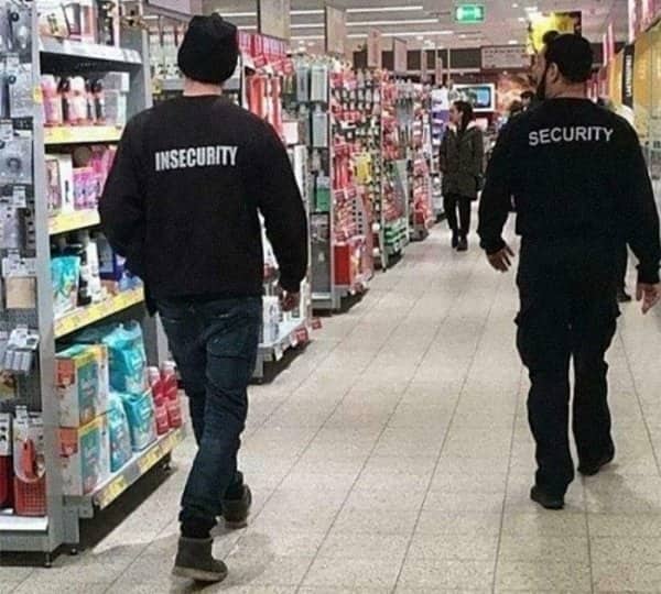 Two men walk through a shop, one jumper reading security and the other reading insecurity.