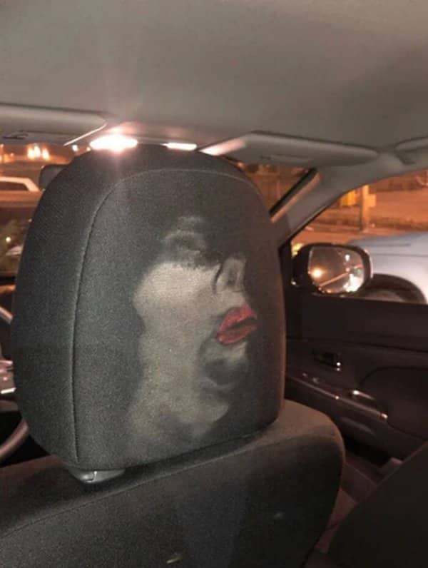 A makeup smear on a car headrest has formed a startlingly clear face at night.