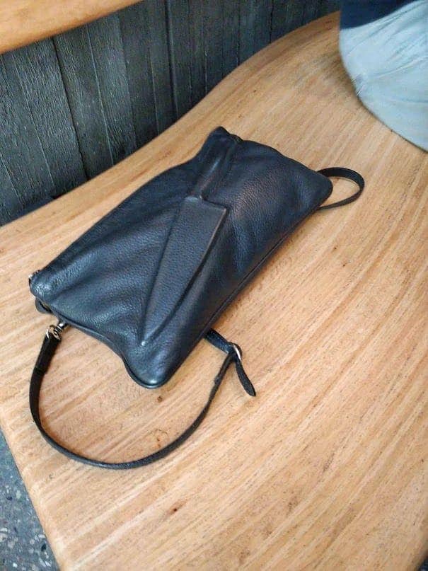 Black leather handbag with a sculpted fold, awful taste but great execution craftsmanship.