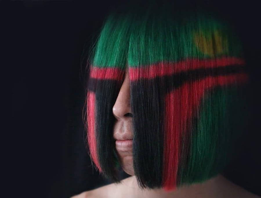 Woman's bob haircut dyed green, red and black to look like Boba Fett's helmet.