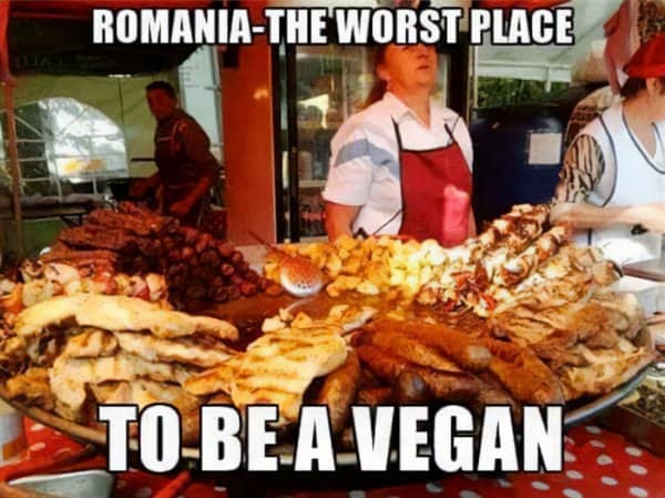 Balkan meme displaying Romanian street market vendor stall piled high with grilled meats and sausages.