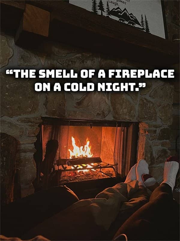 Cozy view of warm feet resting by a crackling stone fireplace representing favorite winter smells.