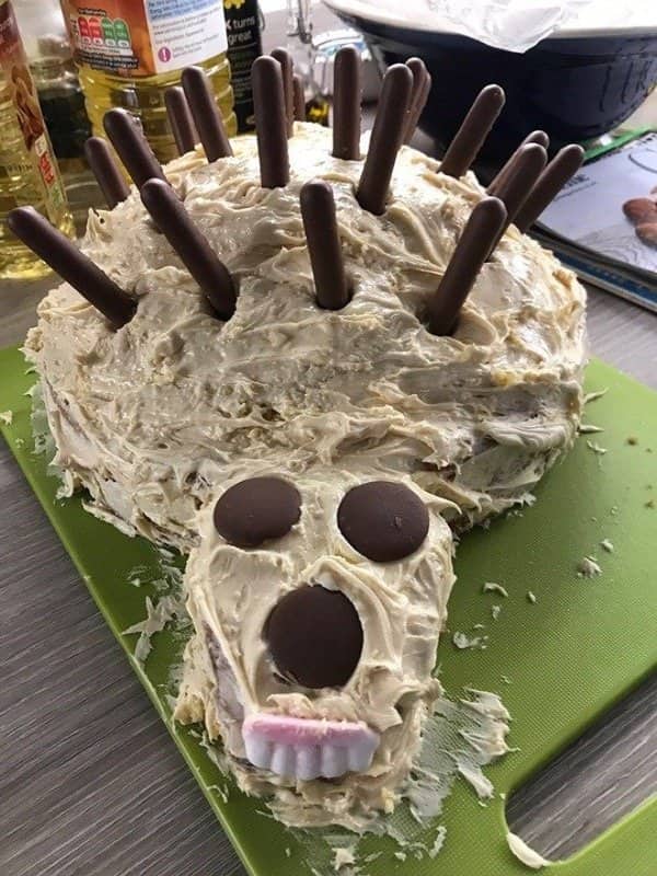 Hedgehog cake with chocolate stick spines and a frosting face frozen in a scream