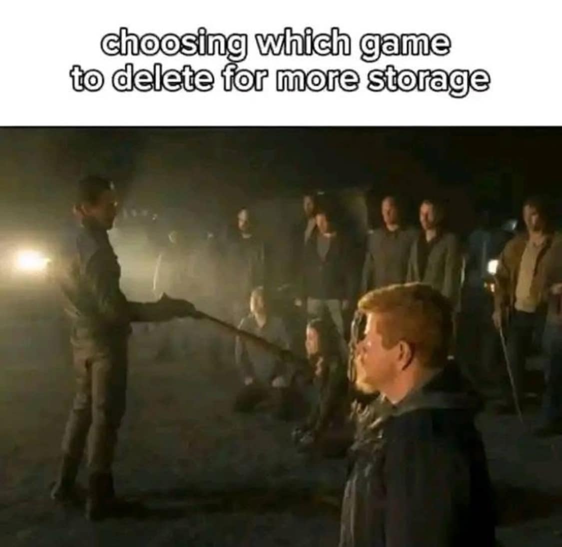 Walking Dead screenshot of Negan holding his bat labeled as deciding which video game to uninstall for hard drive space in a classic meme.