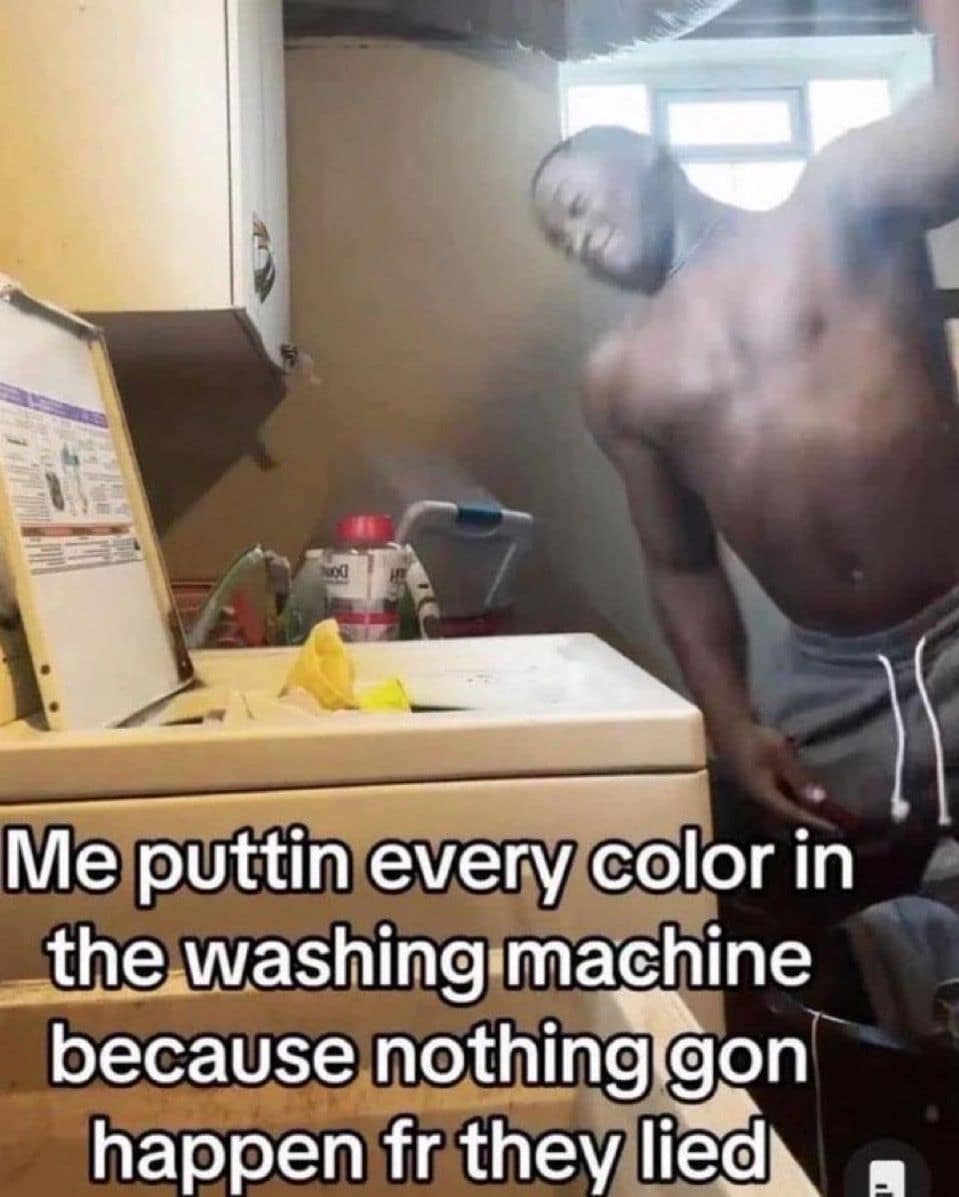 A shirtless man aggressively throwing all colored clothes into a washing machine at once, defying laundry sorting rules in one of the best memes.