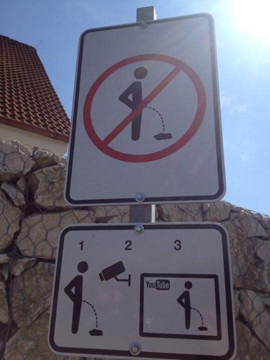 Public warning sign in a classic meme illustrating that public urination caught on security cameras will be posted straight to YouTube.