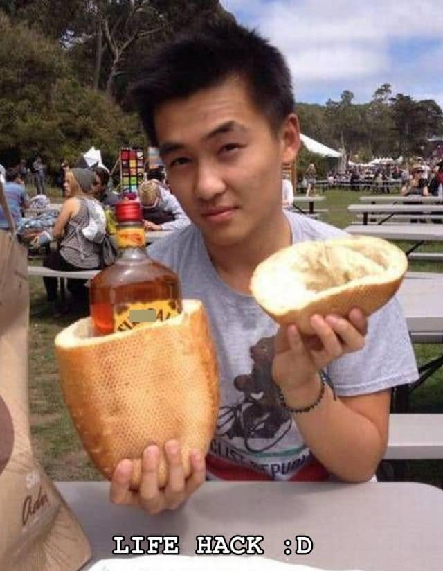 Festival goer holding a hollowed-out baguette carrying a bottle of Fireball whiskey labeled 'LIFE HACK :D' in an old memes classic.