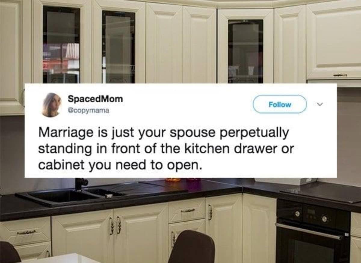 Modern kitchen background overlaid with a tweet describing marriage as your spouse constantly standing right in front of the cabinet you need to open, ranked among the best memes.