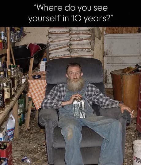 Cluttered shed setup of a bearded man in overalls sipping moonshine labeled as a 10-year life plan in a classic meme.