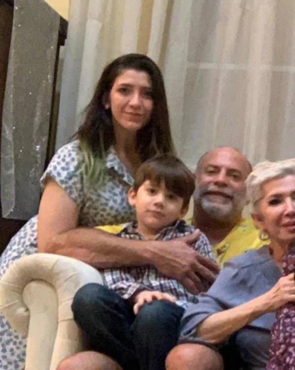 Family photo where a man's arm appears to belong to the woman beside him.