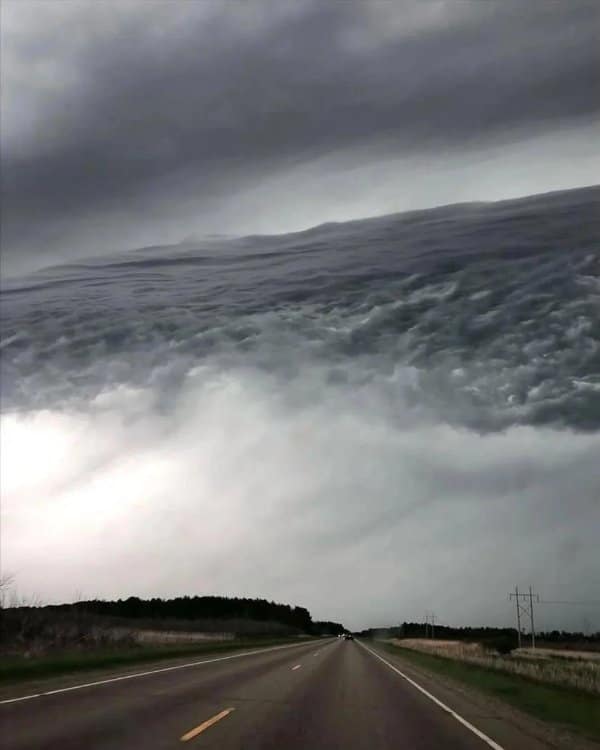 Storm clouds rolling over a highway like an ocean wave, among the eeriest confusing images.
