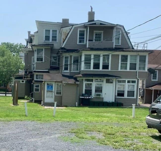 Sprawling house covered with mismatched additions, porches and rooflines.