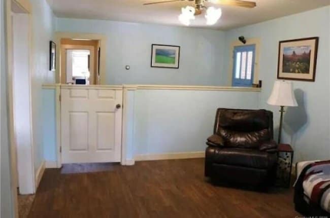 Living room with a half wall and a full size door that nobody needs to open.