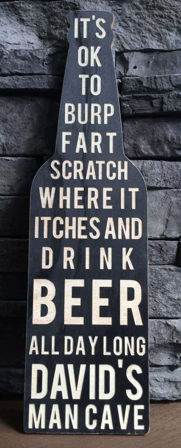 Bottle shaped wooden sign listing man cave rules about burping, scratching and drinking beer