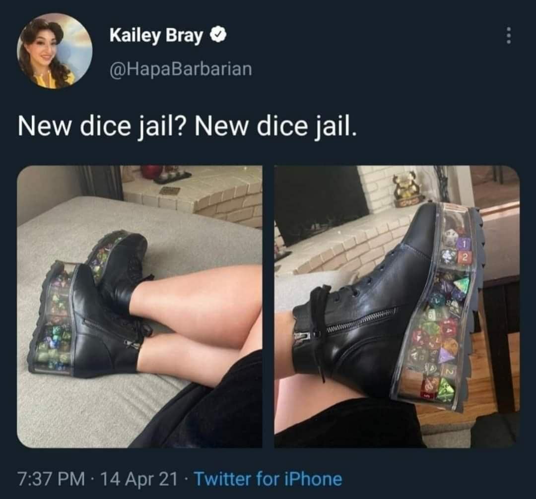 High-platform black boots featuring hollow clear heels completely packed with polyhedral gaming dice, tweeted as 'New dice jail' in a d&d meme.