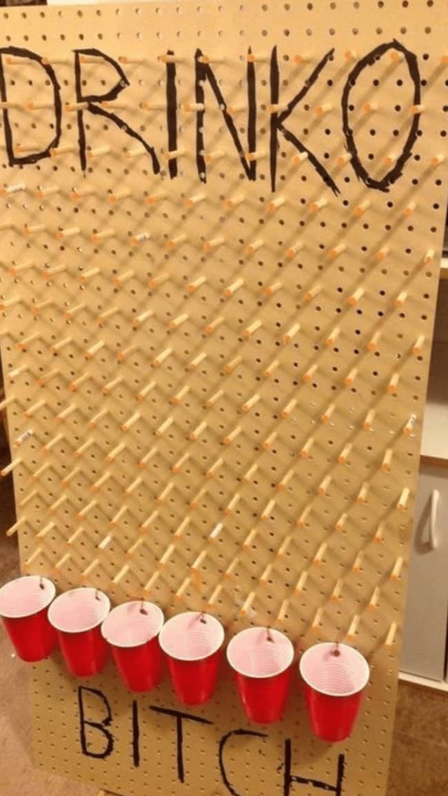 A handmade pegboard Plinko board repurposed as a funny drinking game with red plastic cups.