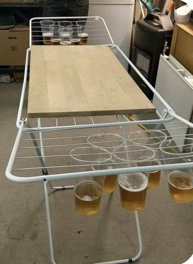 A folding laundry rack repurposed into a table for funny drinking games like beer pong.